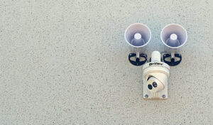 Security system (camera and speakers) mounted on a exterior wall of a building.